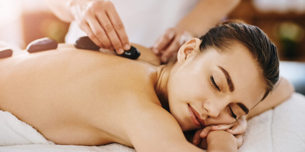 woman smiling peacefully during hot rock treatment at spa